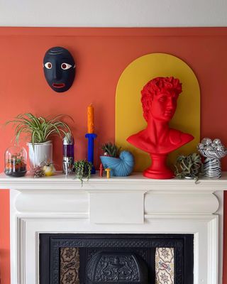 A mantel display of colorful decor and houseplants