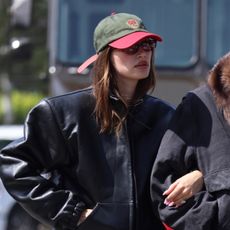 Hailey Bieber wearing a black leather jacket and baseball cap