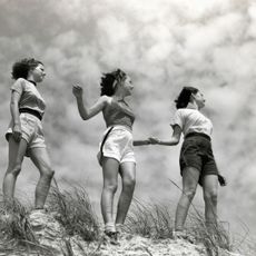 Women holding hands at the edge of a sandbank