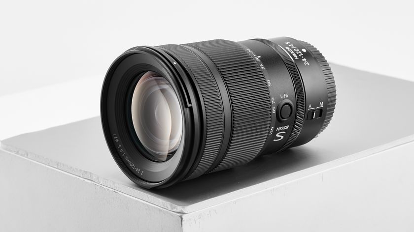 A Nikon Z 24-120mm lens resting on a minimalist gray pedestal, showcasing its sleek design and intricate details