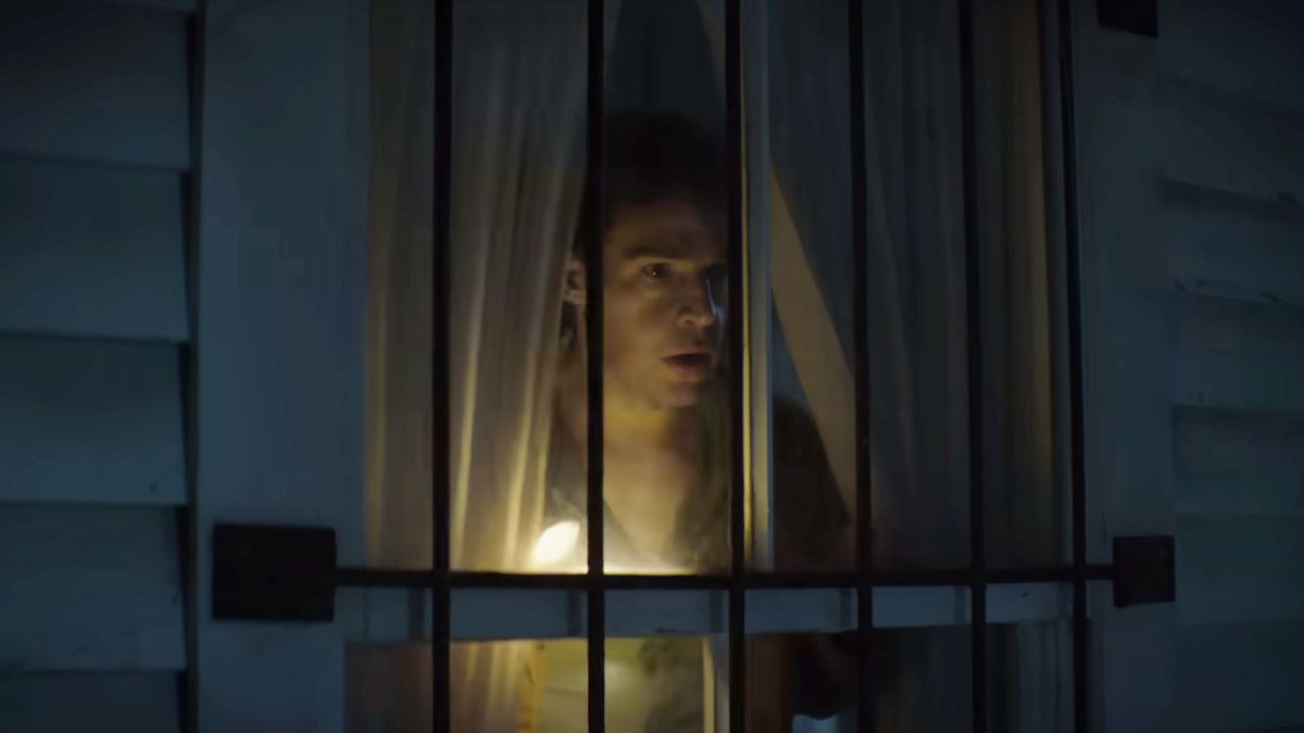 Christopher Abbott as Blake looking out a window in Wolf Man