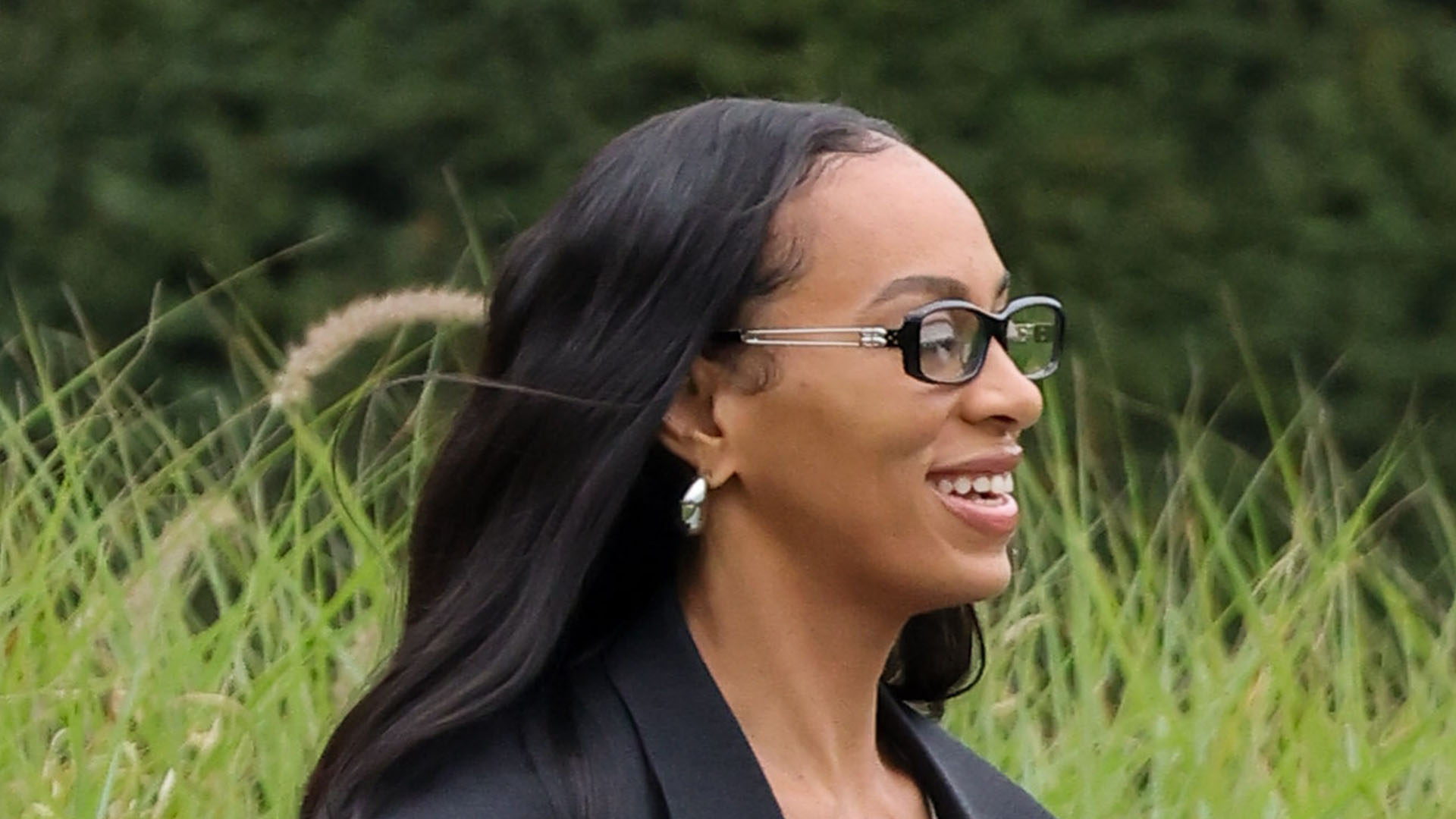 Solange wearing a black coat, baggy jeans, heels, and a Loewe puzzle bag
