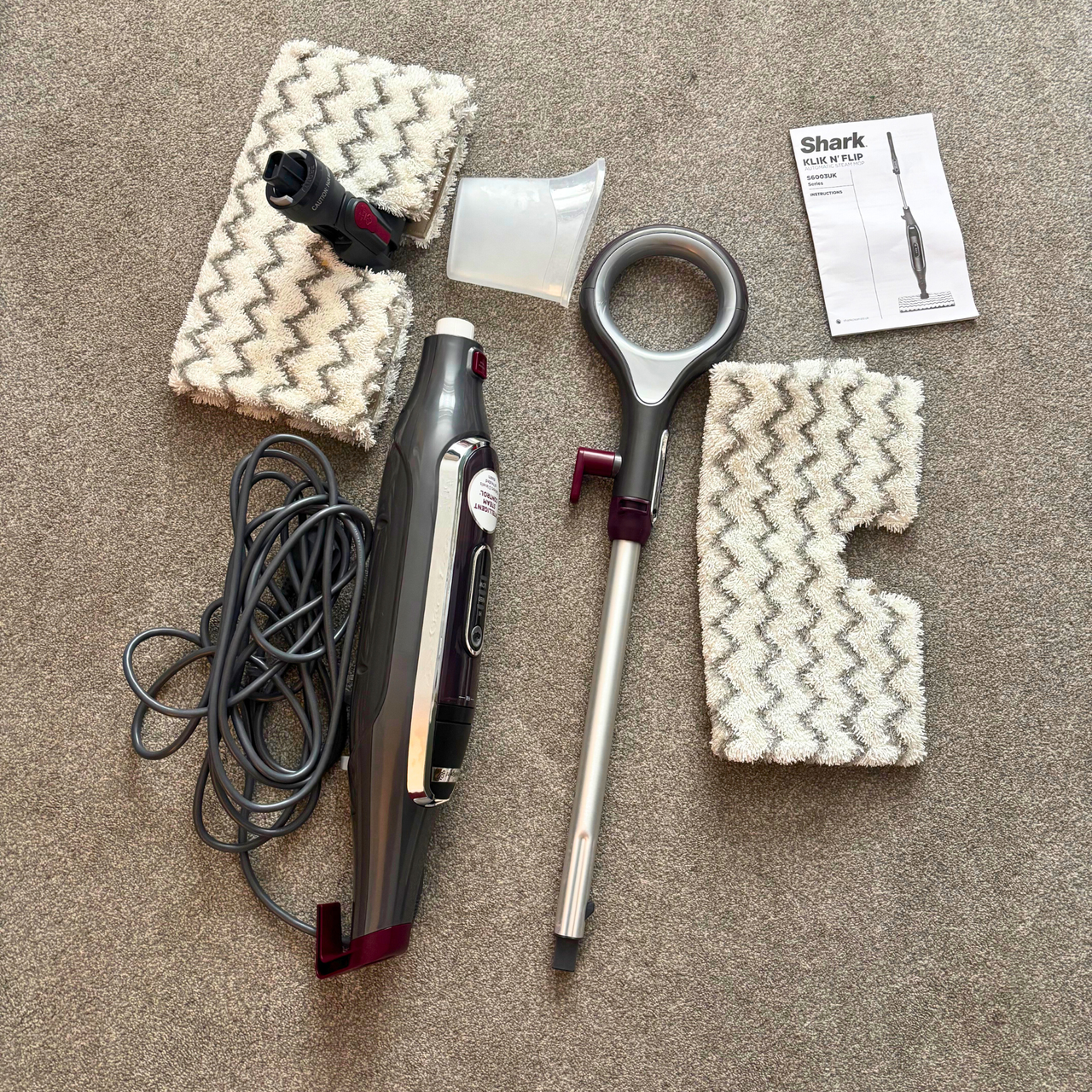 Shark Klik n&rsquo; Flip Automatic Steam Mop flatlay of parts and accessories