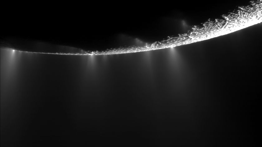 A black and white image of the bottom part of a world in space with hazy plumes shooting out.