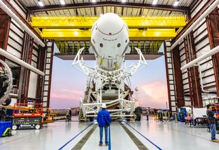 A look at SpaceX's first Crew Dragon spacecraft attached to its Falcon 9 rocket as both sit inside their hangar at Launch Pad 39A of NASA's Kennedy Space Center in Cape Canaveral, Florida in January 2019.