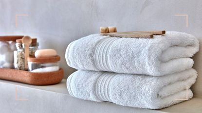 Contemporary concrete bathroom shelf with fluffy white towels to support an article on how often should you wash your towels