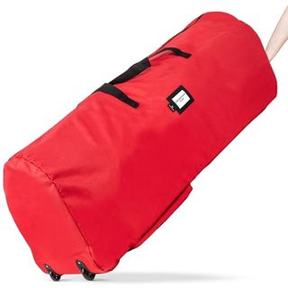 A large red cylindrical fabric storage bag for Christmas trees with a black fabric handle and black plastic wheels