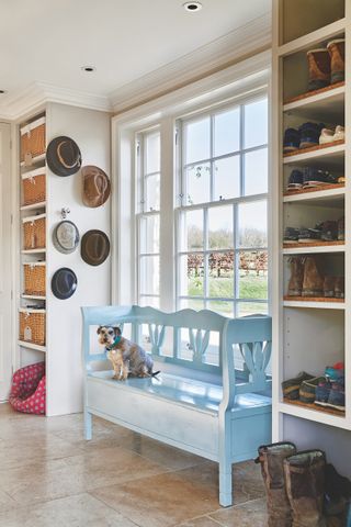 boot room storage built around a window with blue bench