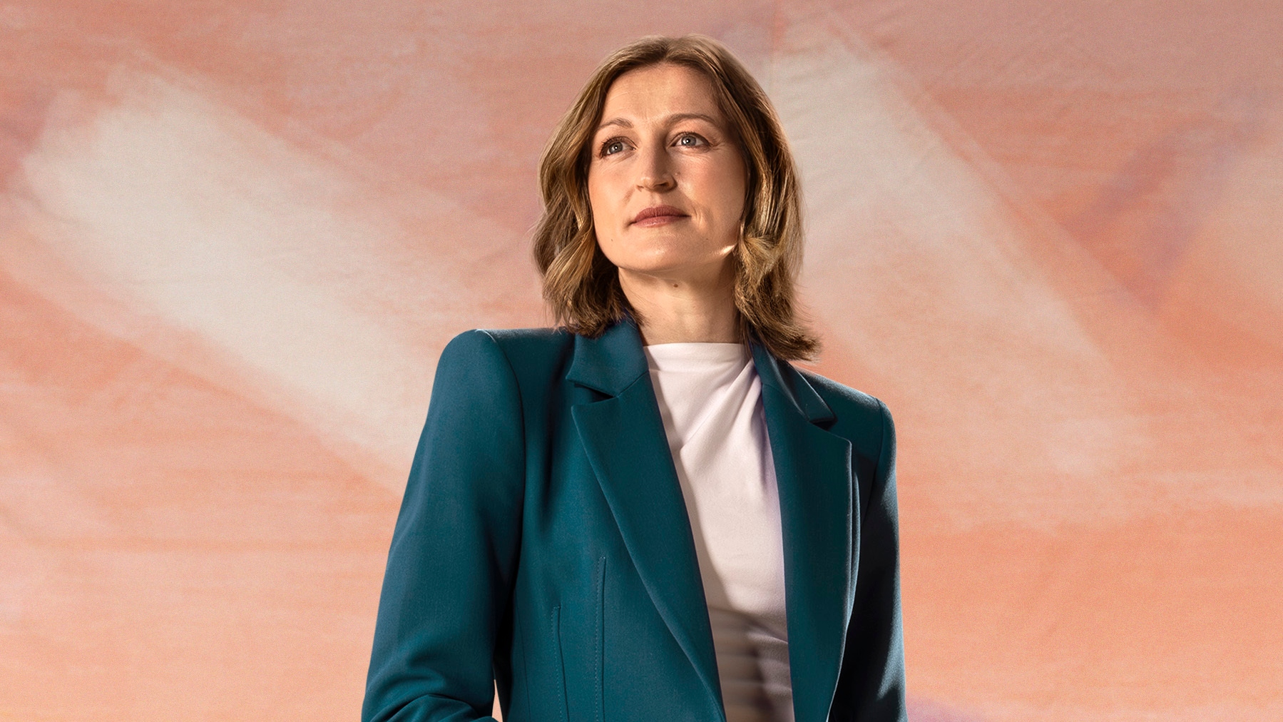 Ellen White looks to the camera wearing suit
