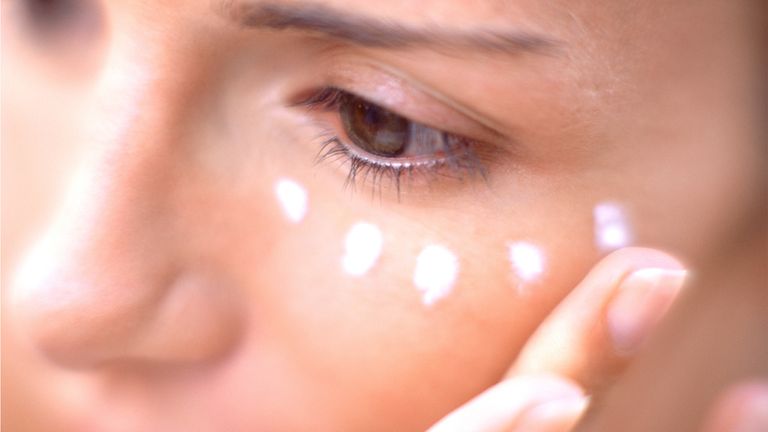 Woman applying dots of eye cream