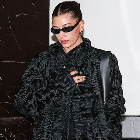 Hailey Bieber added some texture to her all-black outfit in a shearling coat, velvet pants, and a leather tote bag