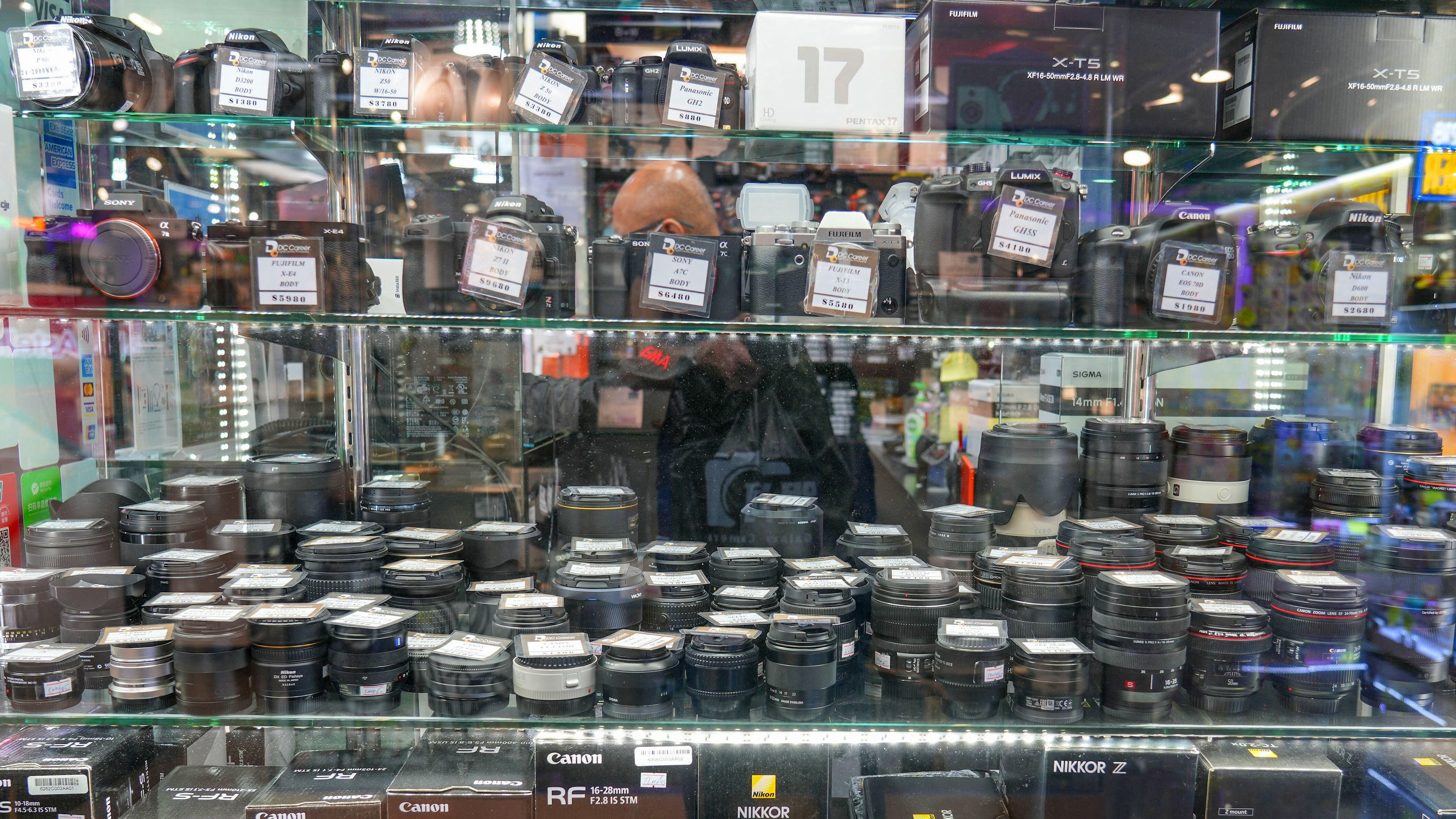 3DG537J HONG KONG, CHINA - NOVEMBER 3, 2025: Lenses in a window of photo equipment shop in Sim City mall specializing in photography equipment in Kowloon