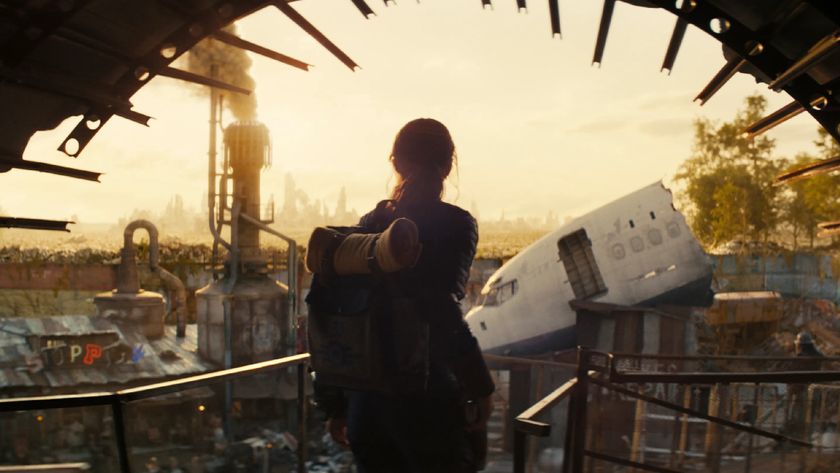 Silhouette of a person looking out onto a ruined landscape