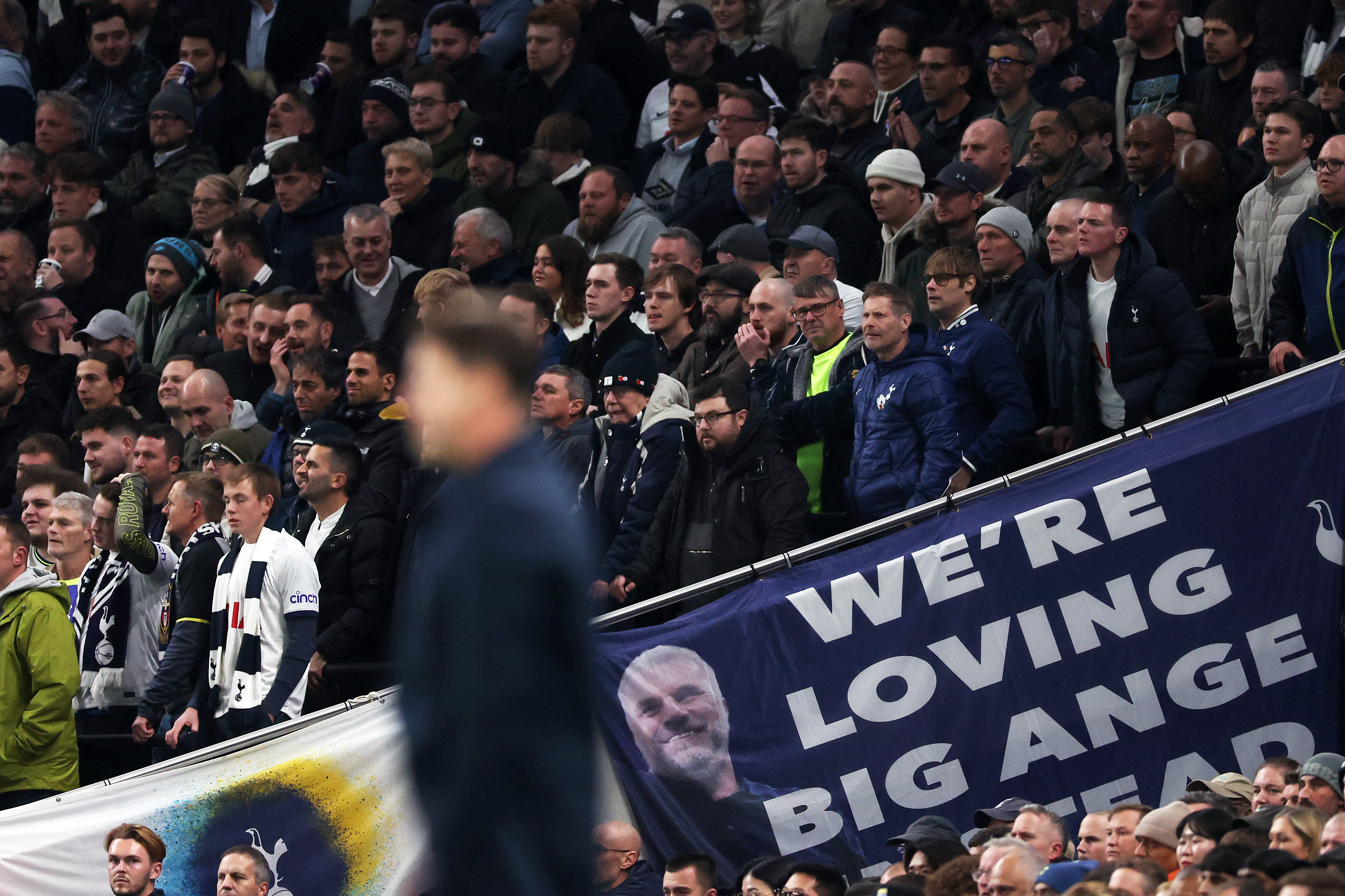 O técnico do Chelsea, Mauricio Pochettino, diante de uma faixa dedicada a Ange Postecoglou durante a vitória dos Blues por 4 a 1 sobre o Tottenham, em novembro de 2023.