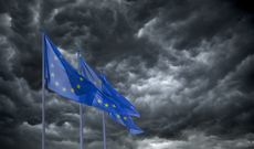 Dark clouds swirl behind the EU flags