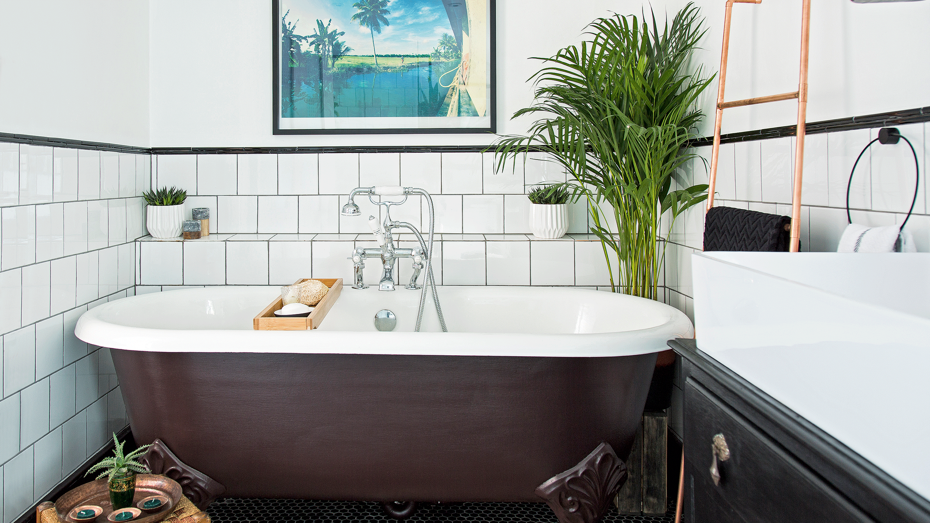 Black bathtub with white tiles and pictures