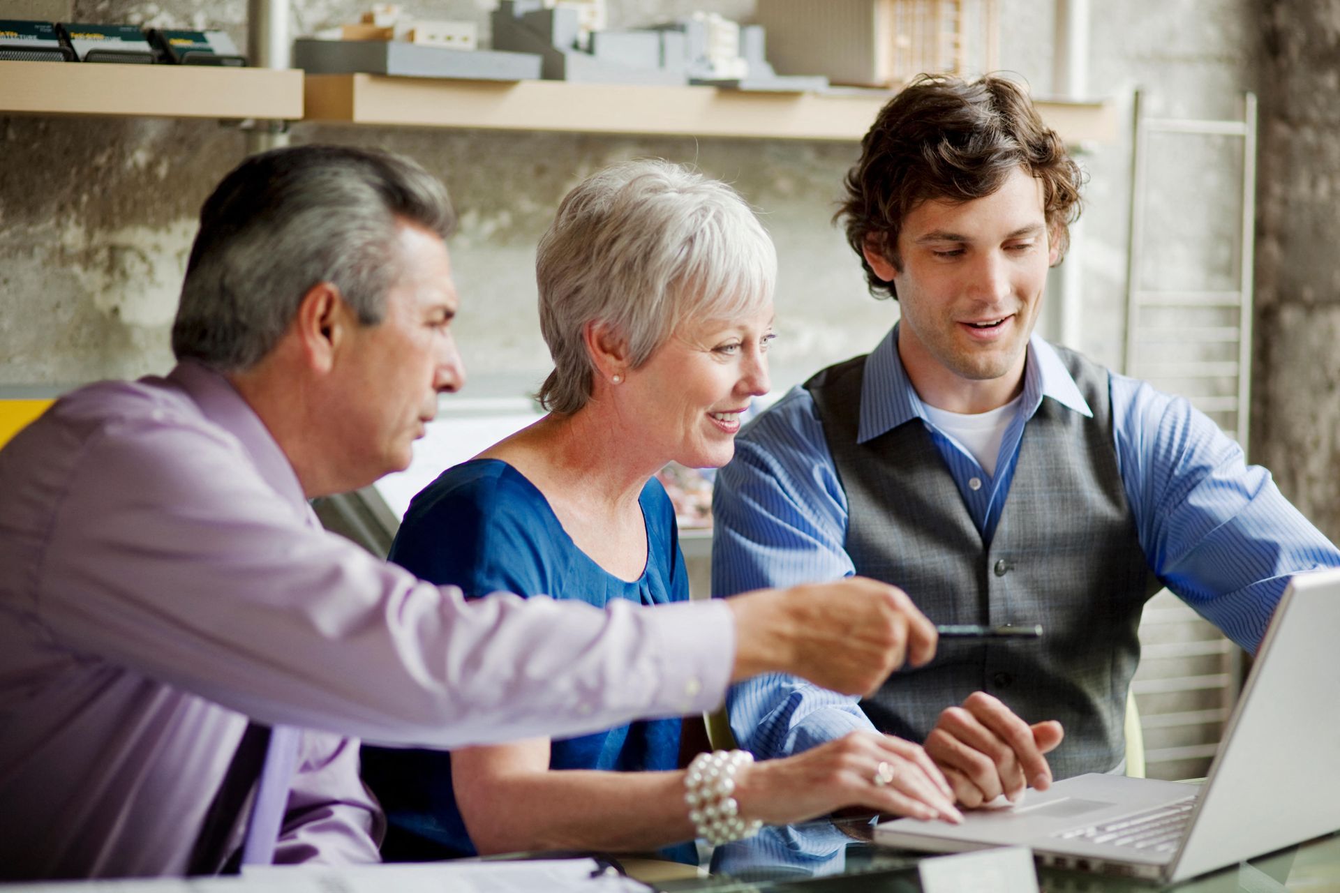 M2E12K Smiling businesspeople using laptop in office