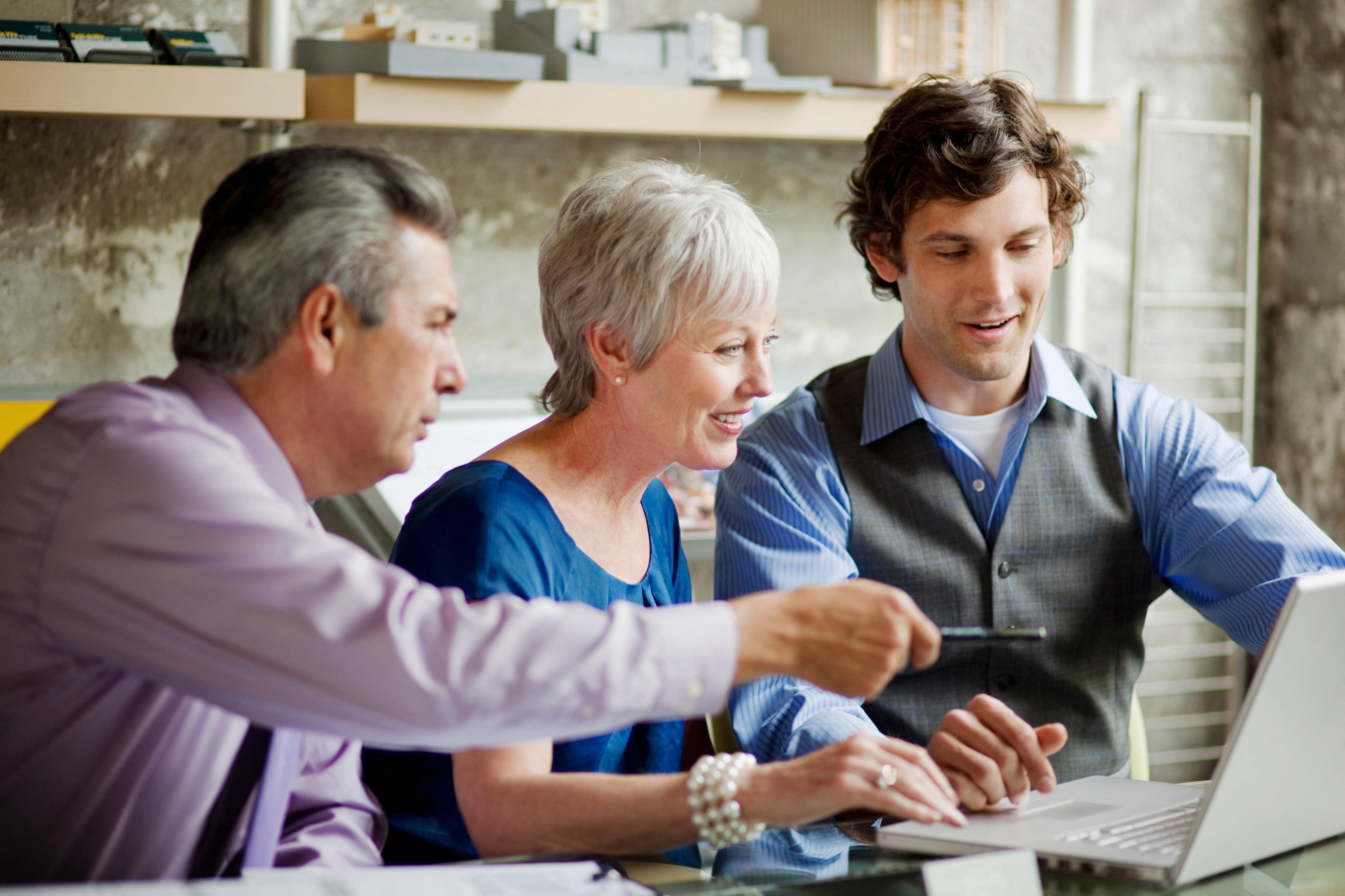 M2E12K Smiling businesspeople using laptop in office