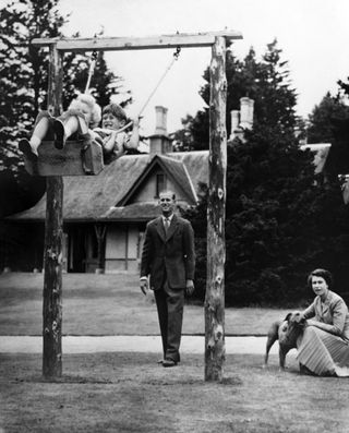 Queen Elizabeth II (R) and Prince Philip, Duke of Edinburgh (C) play with Prince Charles and Princess Anne at Balmoral Castle