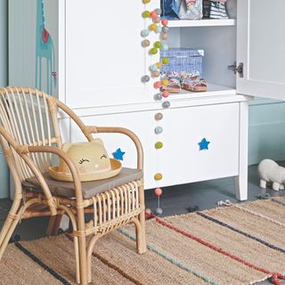 A white IKEA wardrobe in a children's room with star-shaped handles