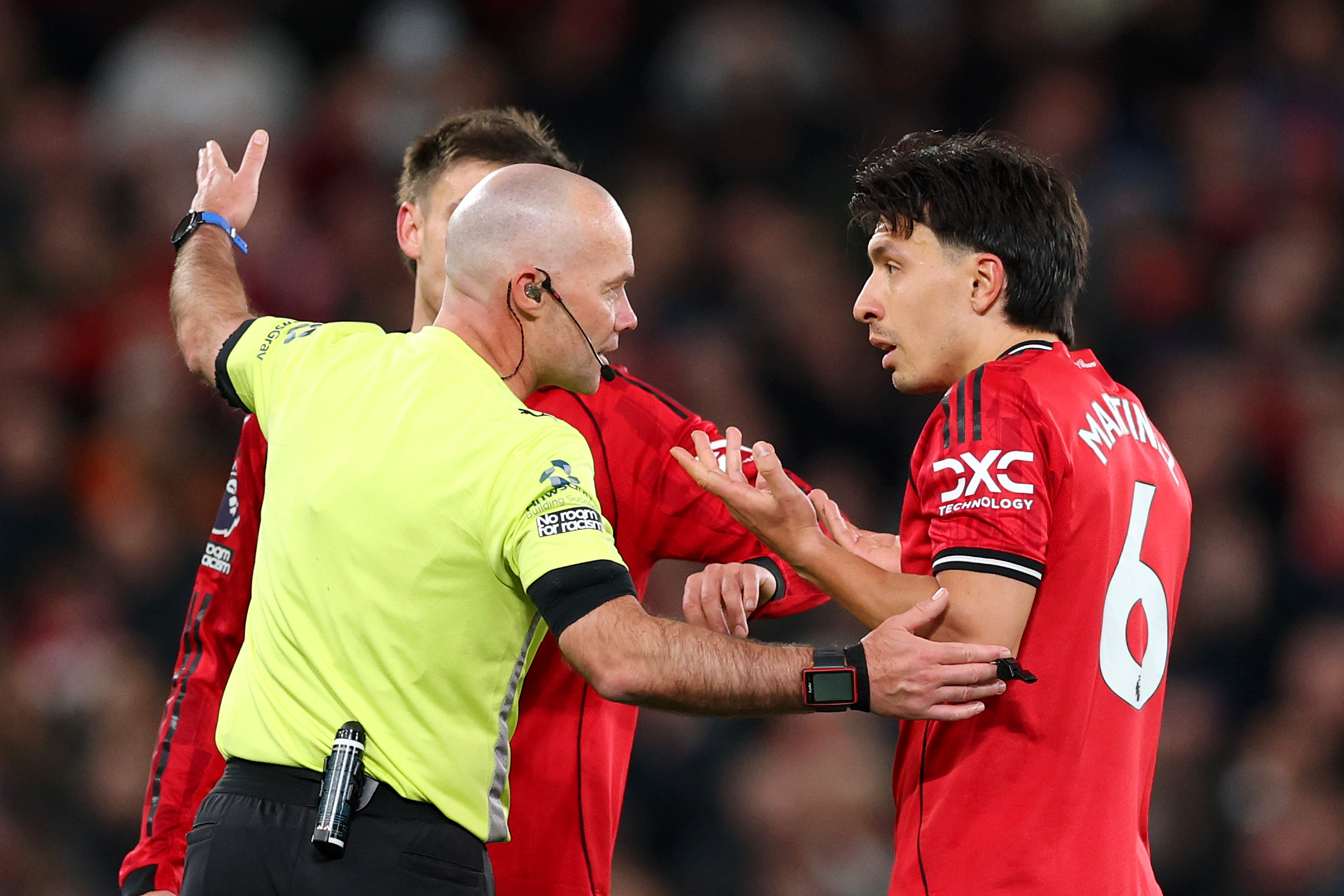 MANCHESTER, ENGLAND - APRIL 13: Referee Paul Tierney speaks with Lisandro Martinez of Manchester United after showing him a red card for pulling the hair of Dominic Calvert-Lewin of Leeds United