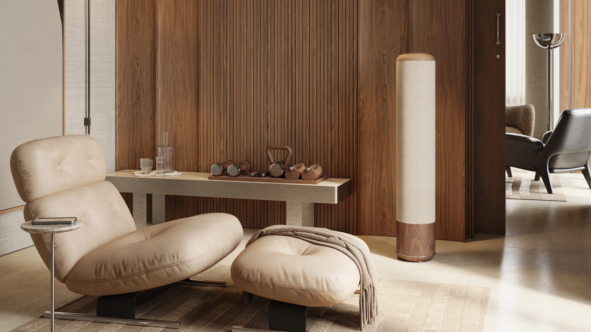 PENT. Audio Chiara speaker next to a wooden panelled wall with a large lounge chair in the foreground