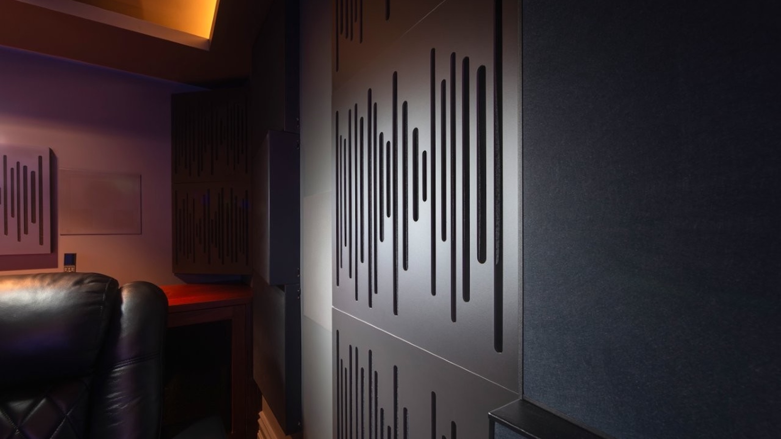 A photo of a custom-installed home cinema room featuring a 4K projector, theatre seating and clever acoustic treatment