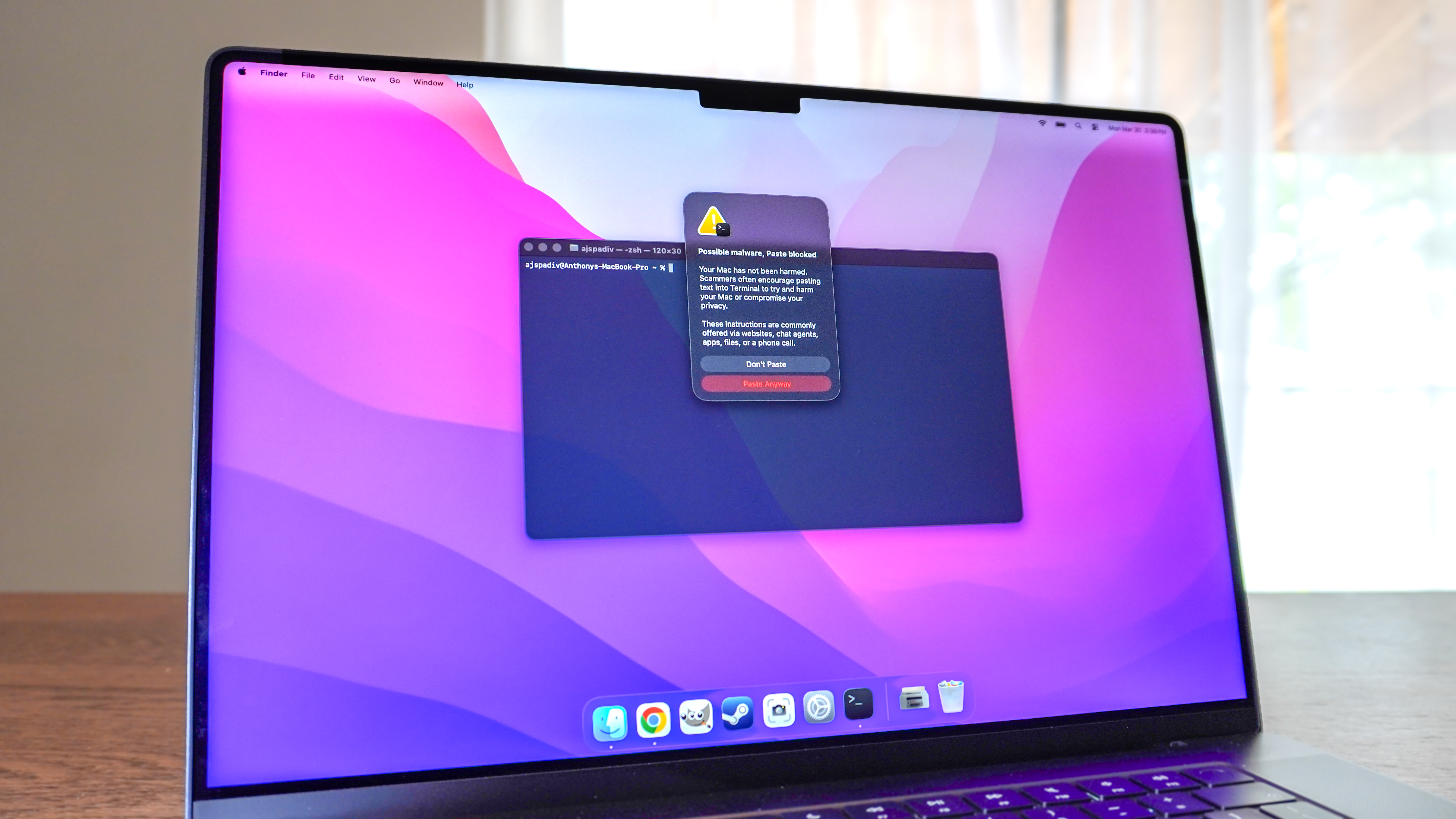 A picture of Apple's new warning message that pops-up when you try to paste into Terminal on macOS 26.4 on a MacBook Pro on a kitchen table