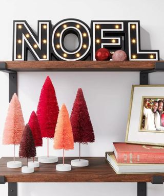 A set of multi colored Christmas tree decorations on a shelf