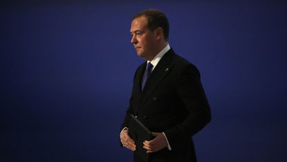 Dmitry Medvedev in front of a blue background