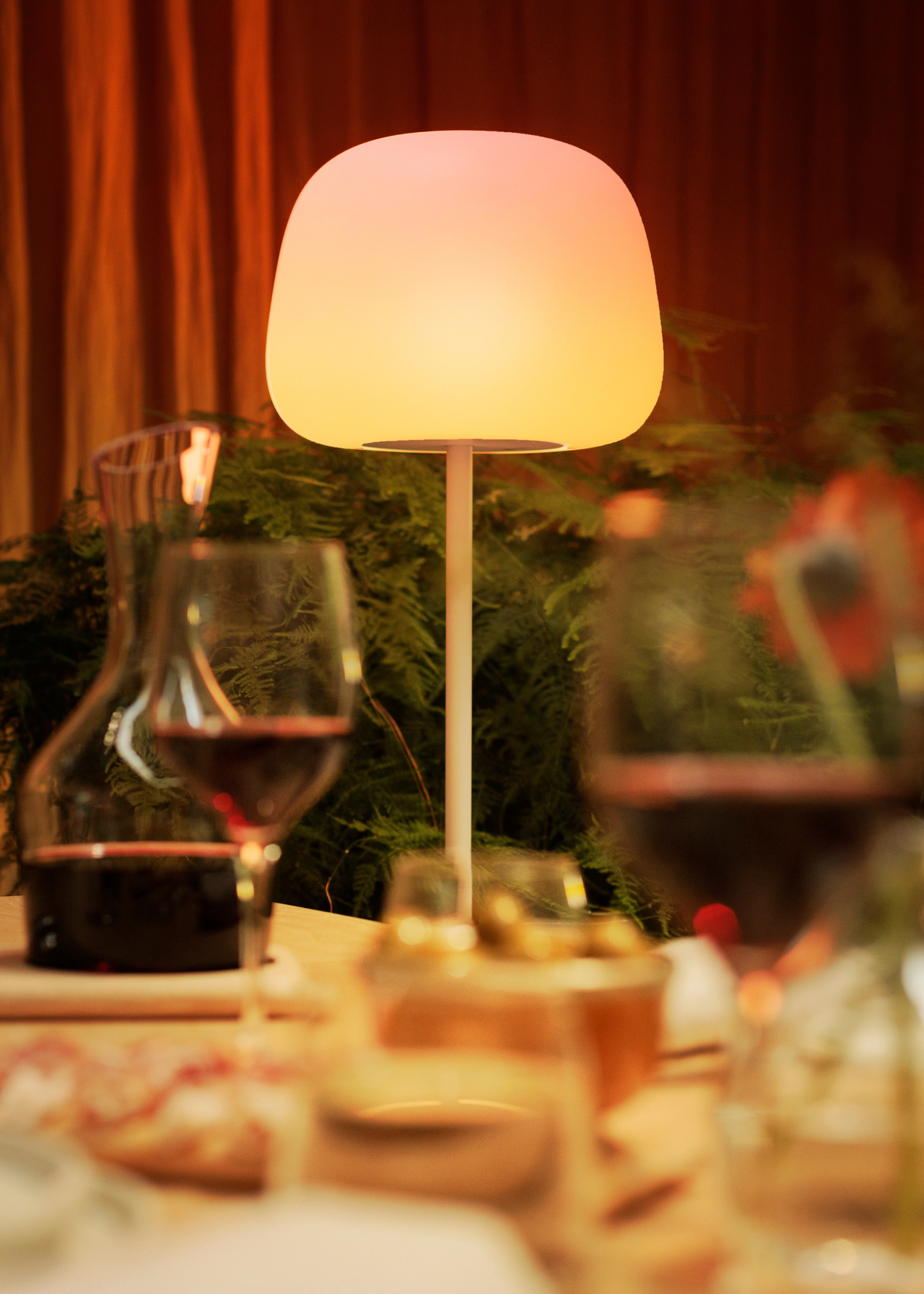 A close-up of a warm yellow lamp by a dining table from Govee