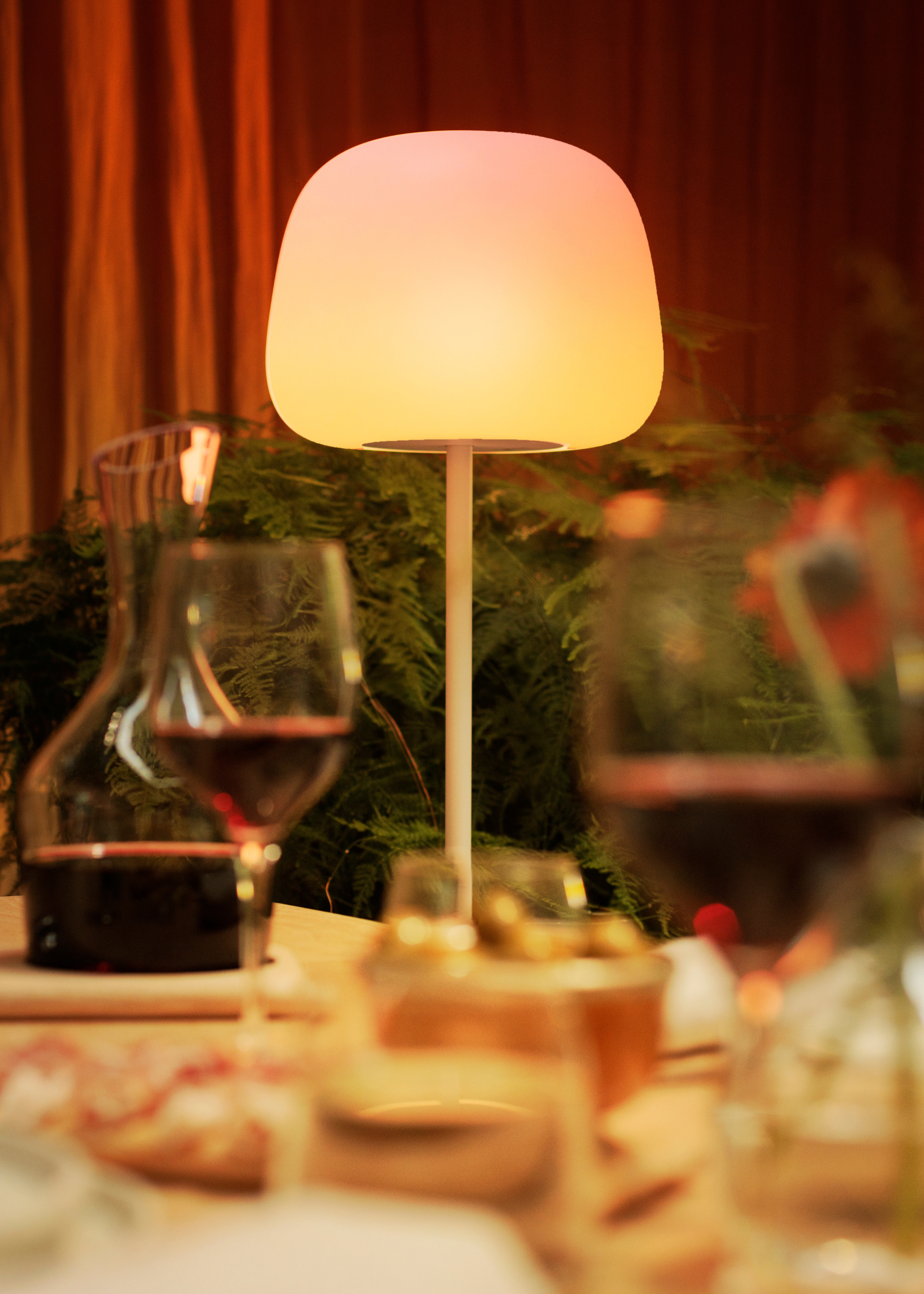 A close-up of a warm yellow lamp by a dining table from Govee
