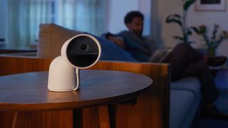A Philips Hue Secure camera sitting on a table in a living room