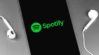 spotify on a smartphone with some earbuds