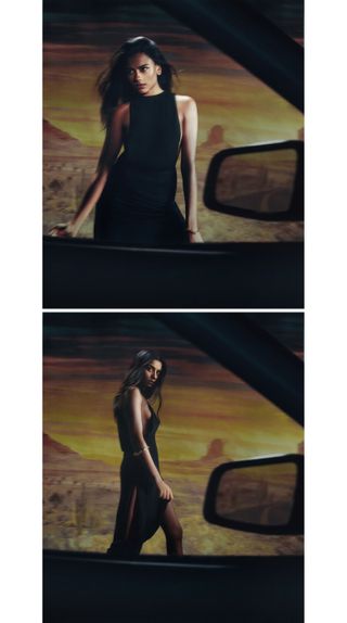 Simone Ashley photographed from a car window walking in front of a desert landscape backdrop wearing a black dress.