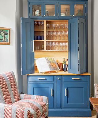 dining room with blue dresser with bar and striped chair