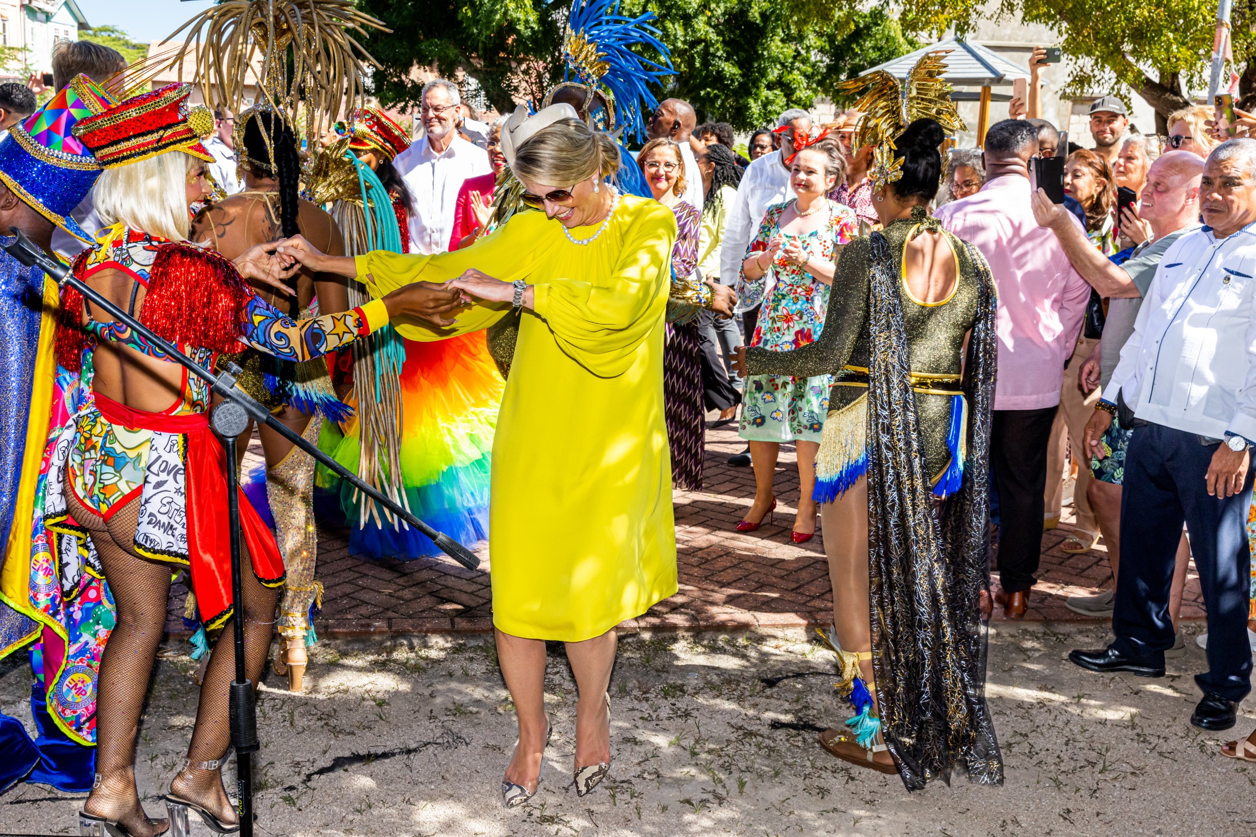 Queen Maxima dancing in a yellow dress in Curacao