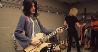 Joe Perry backstage with Aerosmith in 1976, noodling on a B.C. Rich Mockingbird in a natural finish