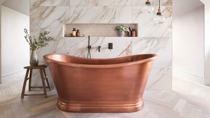 copper bath interior and exterior freestanding in light tiled bathroom