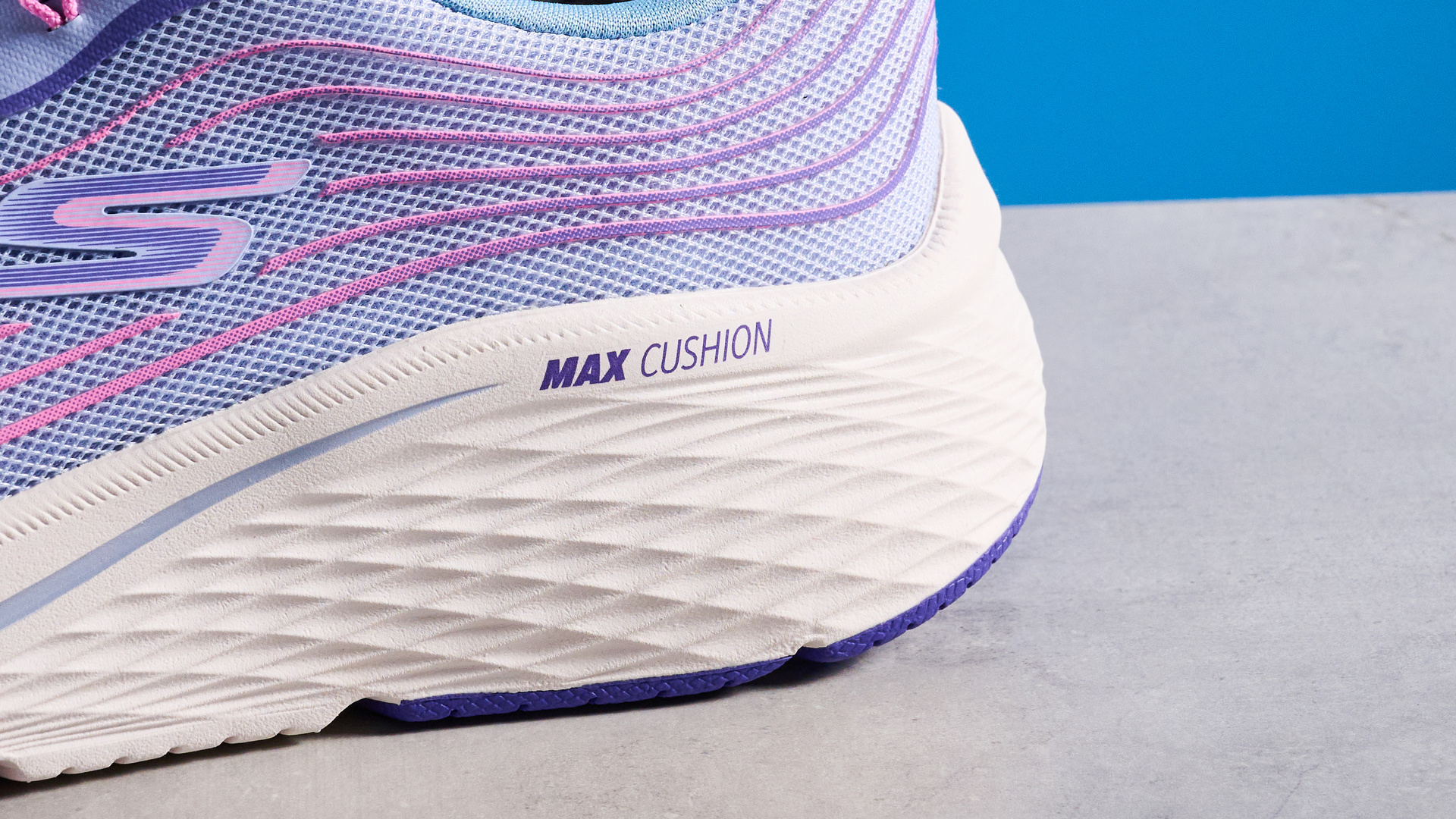 Skechers Max Cushioning Elite 2.0 running shoes photographed in front of a blue background.