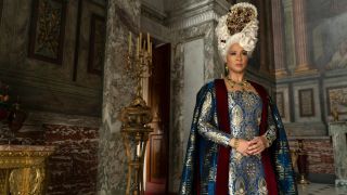 Golda Rosheuvel as Queen Charlotte standing in a big room wearing a dark blue gown.