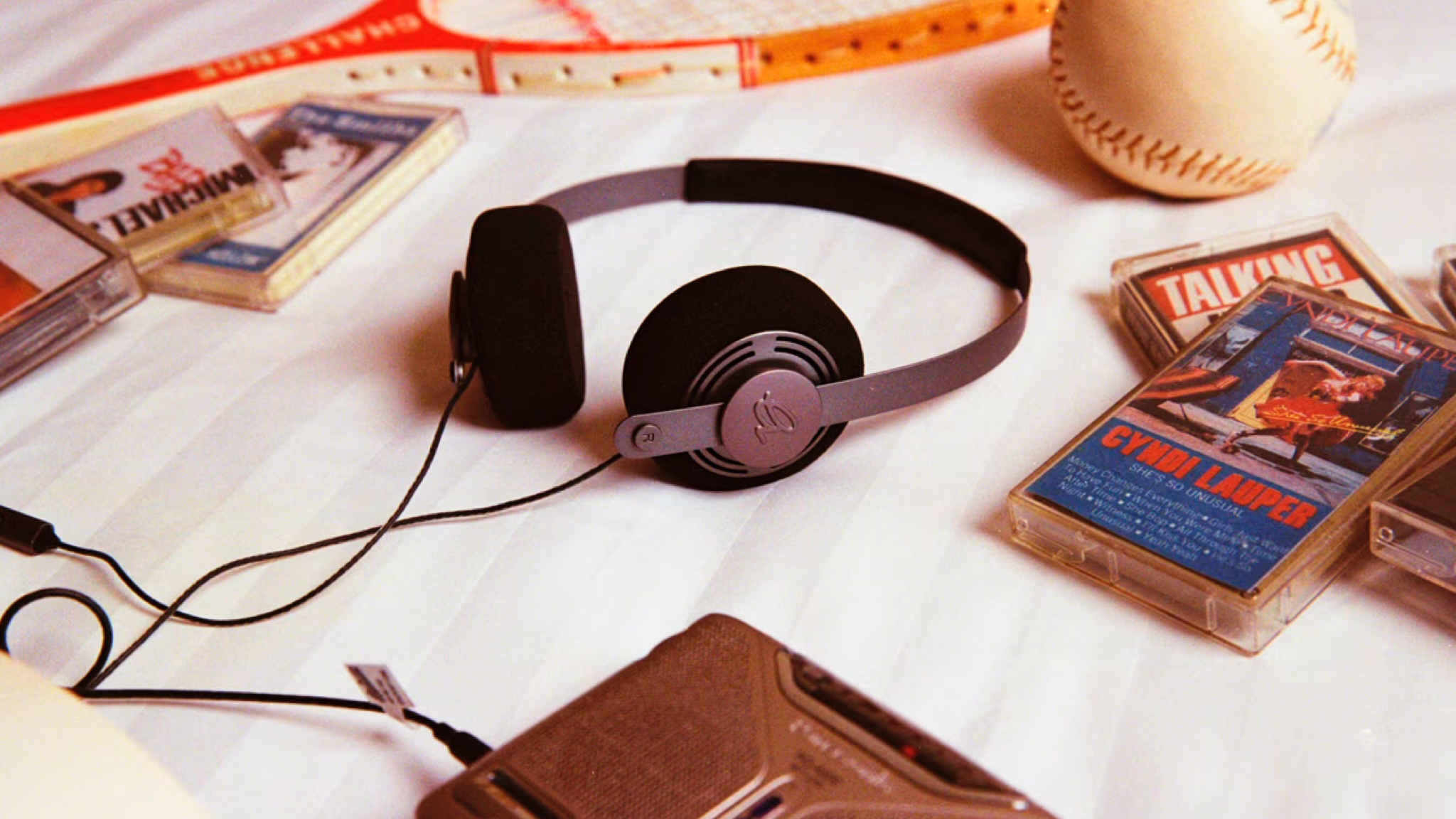 A product shot of the Gadhouse Wesley headphones surrounded by cassette tapes on a light coloured background