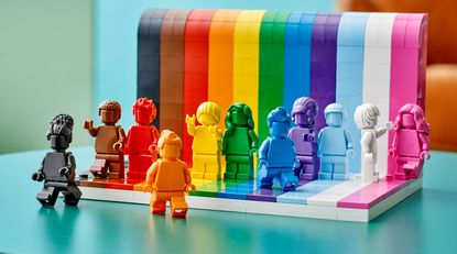 Rainbow coloured Lego figures against a rainbow Lego background