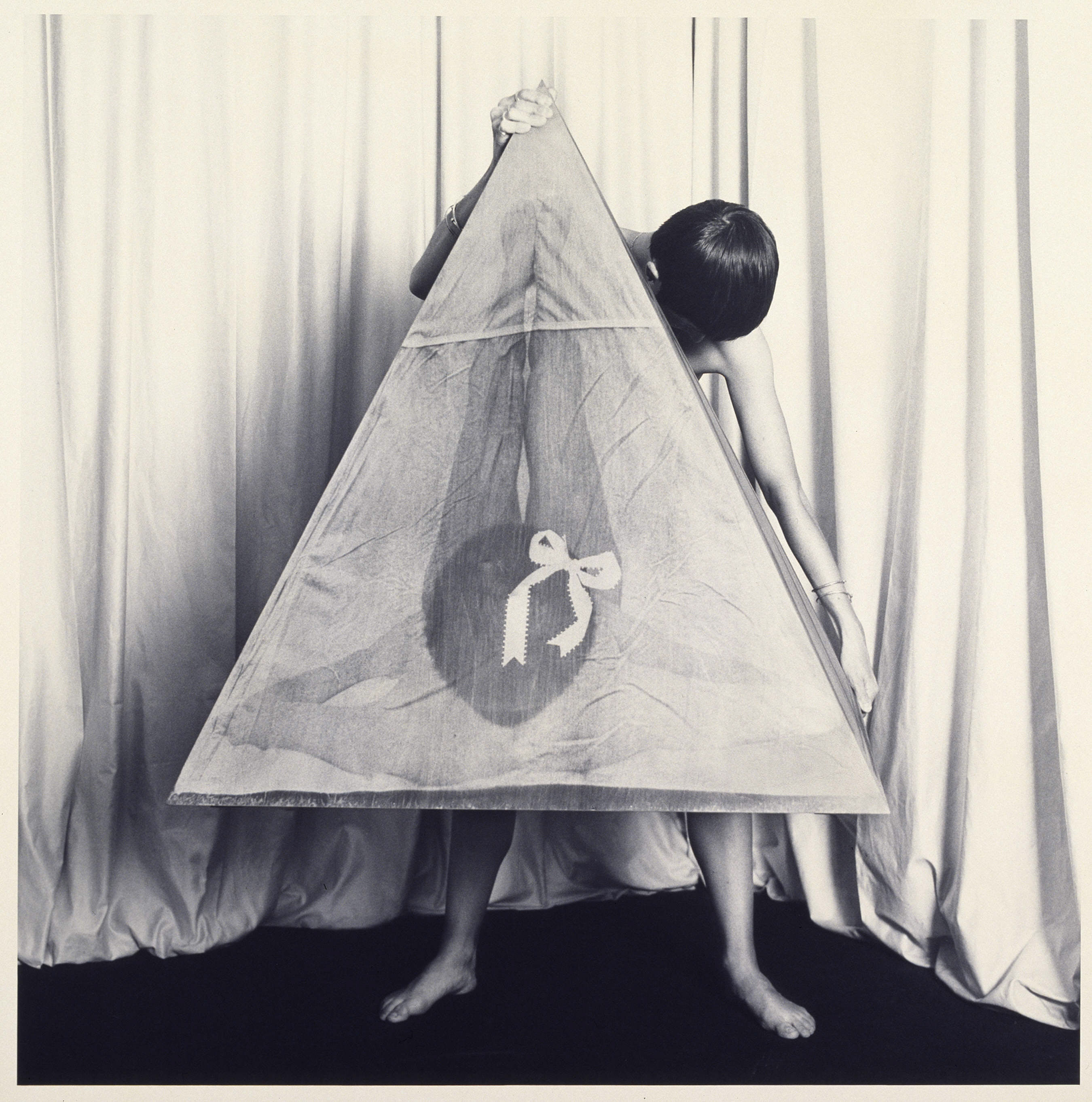 black and white photo of woman holding triangular artwork