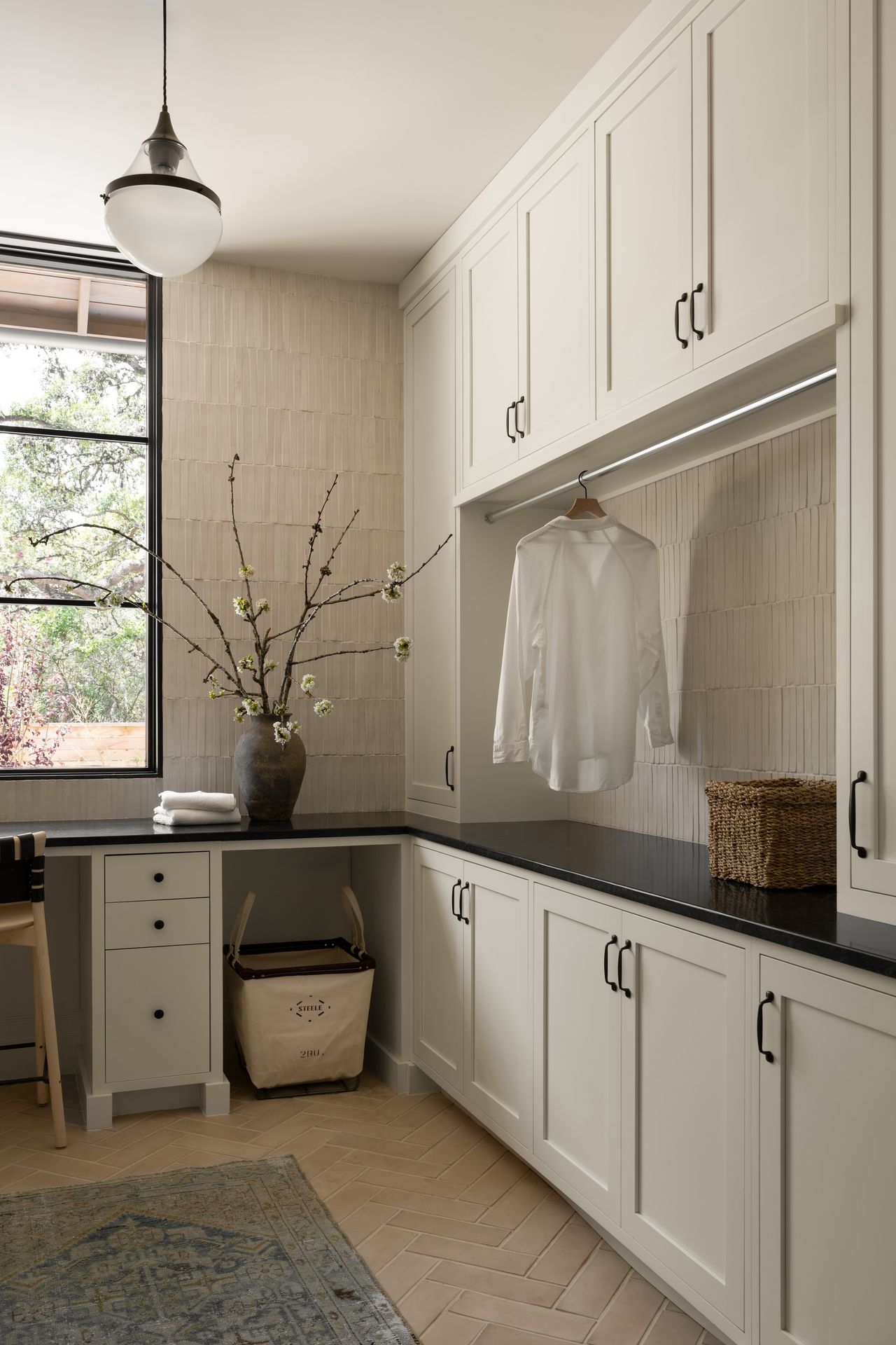A laundry room with closed cabinetry and a built-in clothing rod