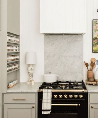 A white kitchen with a space rack built into the side of a wall unit