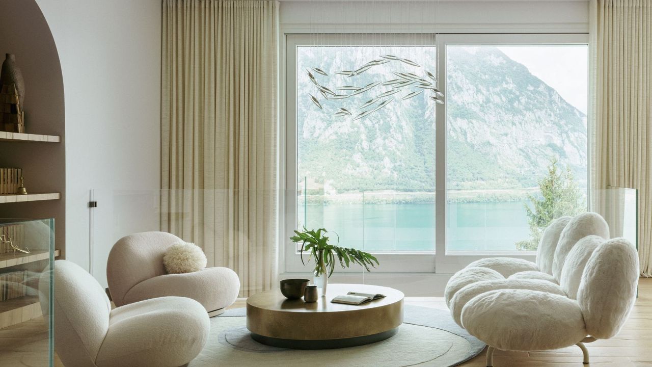 living room with view of lake and white sofas 