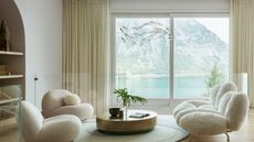 living room with view of lake and white sofas 