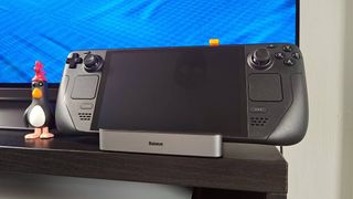 Steam Deck sitting on Baseus Steam Deck dock with Feathers McGraw figure on left.