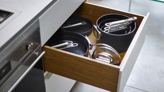 Space folding cookware range in drawer